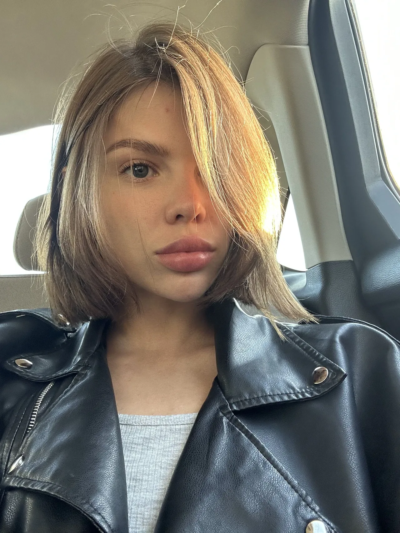Ani Butler, brunette webcam model, in a black leather jacket looking into the camera